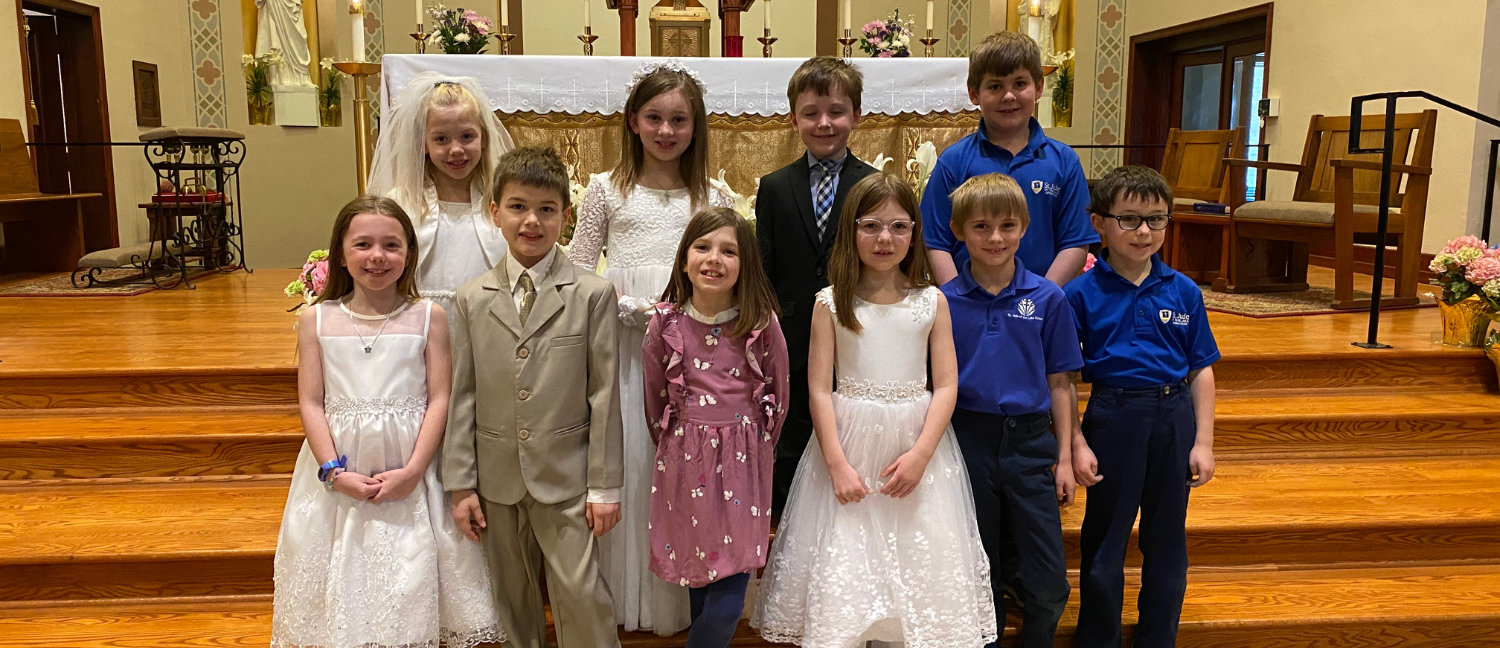 students in first communion apparel smile at the camera in the top-rated catholic elementary and middle school in mahtomedi